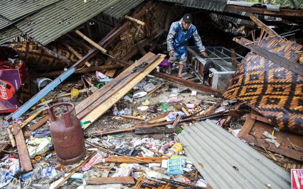 A man walks near a damaged building in Banten.