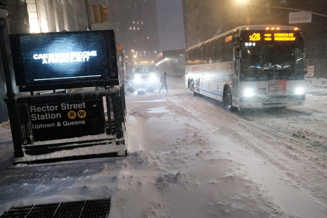 New York traffic moves through lower Manhattan in the pre-dawn hours as a winter storm brings heavy snow, freezing temperatures and strong winds.
