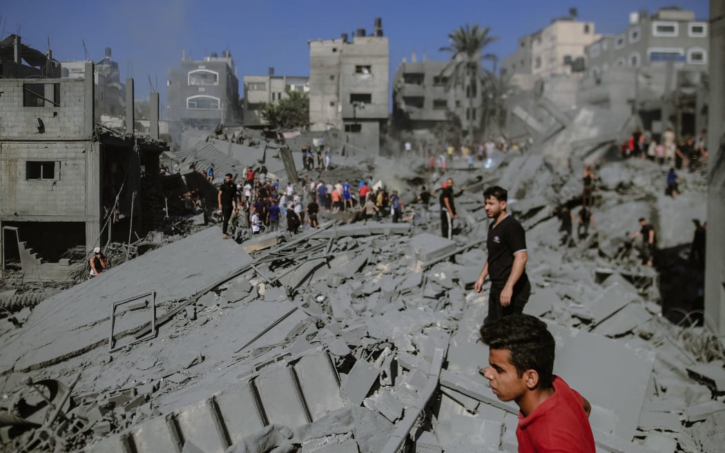 10/26/2023, Gaza, Palestine.  After the Israeli airstrike on the 20th day of the conflict in the city of Khan Yunis, the landscape is one of devastation. Many buildings now stand as little more than rubble, while others are heavily damaged. In this dire situation, brave individuals are working tirelessly to rescue survivors and recover the bodies of those who may have tragically perished in the debris of the destroyed houses. (Photo by Mohammad Zanoun / Middle East Images / Middle East Images via AFP)