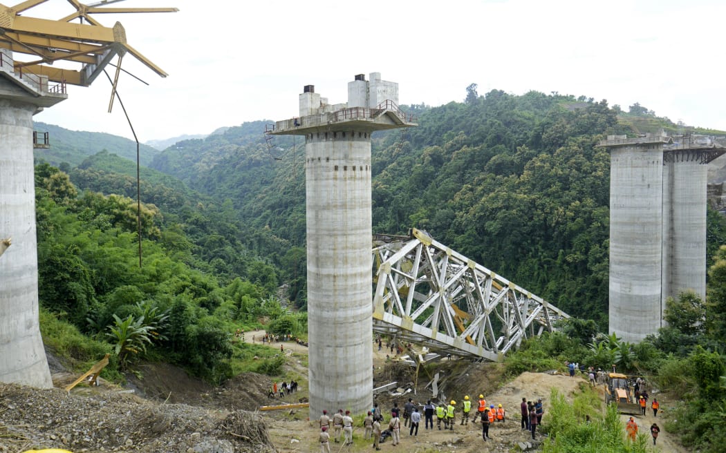 Rescue workers conduct a search operation at the site of an accident where an under-construction railway bridge collapsed in Sairang town of the Aizwal district in India's eastern state of Mizoram on August 23, 2023. At least 17 labourers working on a railway bridge being built across a ravine in India's eastern Mizoram state were killed when it collapsed on August 23, officials said, with others reported missing. (Photo by AFP)