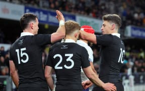 Will Jordan celebrates his try with Damian McKenzie and Beauden Barrett.
