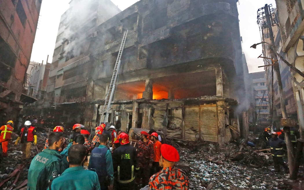 Firefighters are seen at the scene of a fire in Dhaka on February 21, 2019.