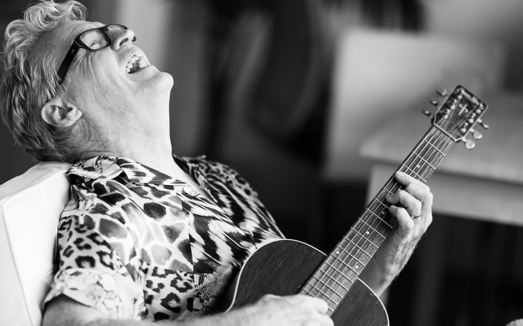 Don McGlashan laughing and playing guitar