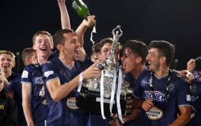 Auckland City players celebrate winning the national football title.