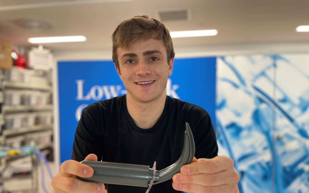 Student Engineer of the Year, Francis Pooke with his new tracheostomy kit device. The device is cylindical wiht a long curved horn-shaped dialator at one end.