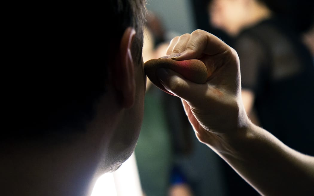 Tom gets a quick lesson on how to apply a full face of drag makeup.