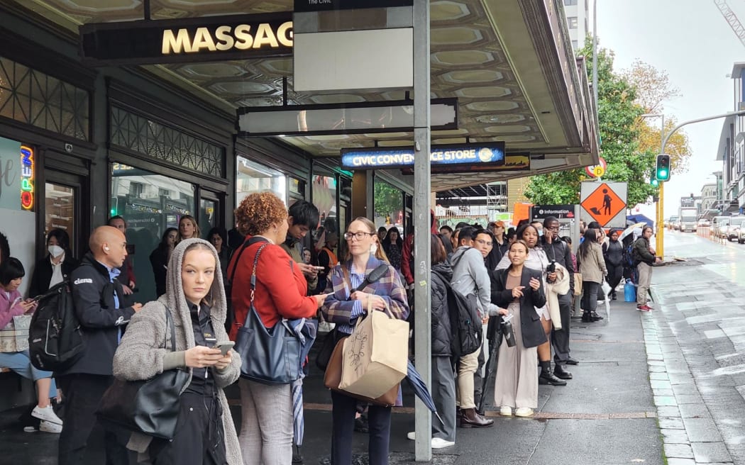 People queued up waiting for a bus to arrive on Wellesley Street on 9 May, 2023.