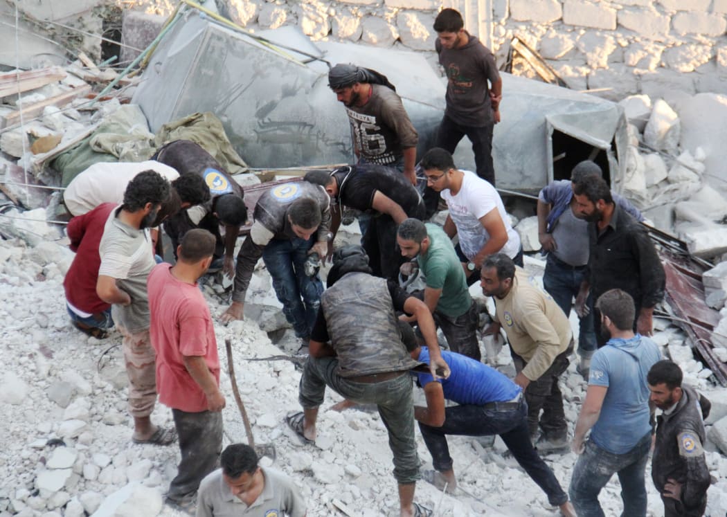Residents and members of the Syrian Civil Defence, also known as White Helmets, search for victims amid the rubble of a building following a reported air strike in the northwestern town of Harim in Idlib province, on 29 September 2017.