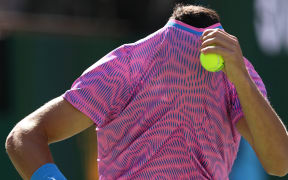 Carlos Alcaraz of Spain hides under his shirt as a swarm of bees invade the court whilst playing against Alexander Zverev of Germany in their Quarterfinal match during the BNP Paribas Open at Indian Wells Tennis Garden on March 14, 2024 in Indian Wells, California.