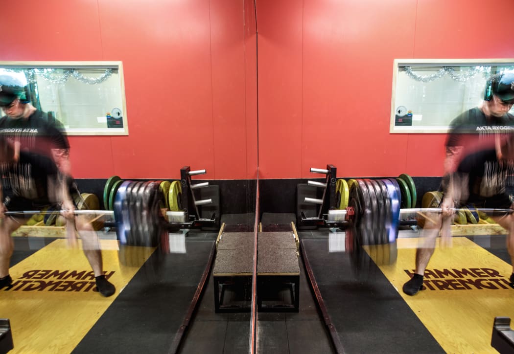 Artistic shot of Chris Kennedy lifting weights