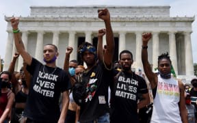 Demonstrator raise their fists at the Lincoln Memorial during a protest against police brutality and racism.