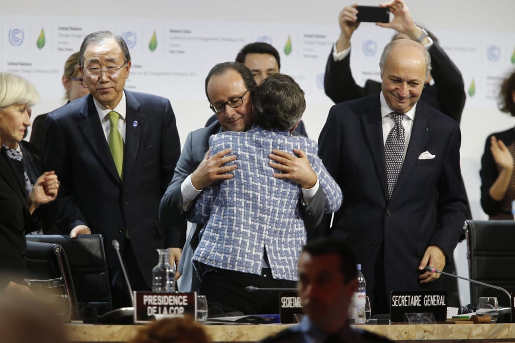 United Nations Framework Convention on Climate Change executive secretary Christiana Figueres and France's President Francois Hollande hug after the adoption of the deal.