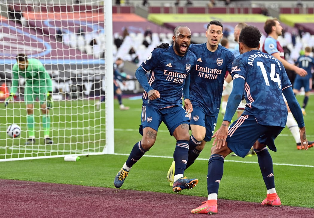 Arsenal's French striker Alexandre Lacazette, left, celebrates scoring his team's third goal during the English Premier League football match between West Ham United and Arsenal at The London Stadium, in east London on March 21, 2021.