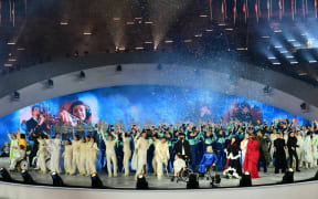 Dancers, performers and attendees including Italian performance artist and choreographer Chiara Bersani (Bottom C) and German aerospace engineer Michaela Benthaus stand on stage at the end of the Milano Cortina 2026 Winter Paralympic Games opening ceremony at Arena di Verona in Verona on March 6, 2026.