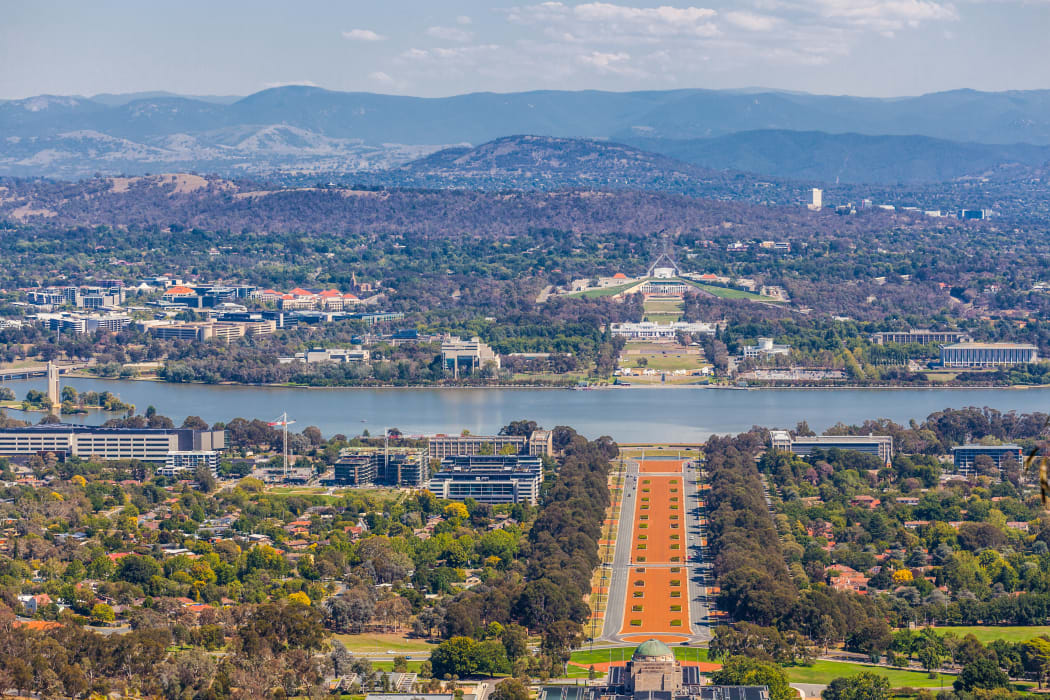 View of Canberra  from Mount Ainslie lookout - ANZAC Parade, Parliament House and modern architecture with mountains in background.