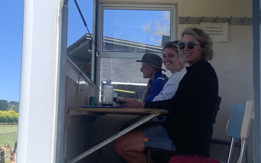 Volunteers keep score next to the commentator during a polo game