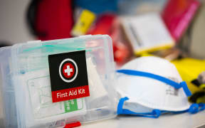 Disaster Preparedness kit.  First Aid Kit in foreground with breathing maks