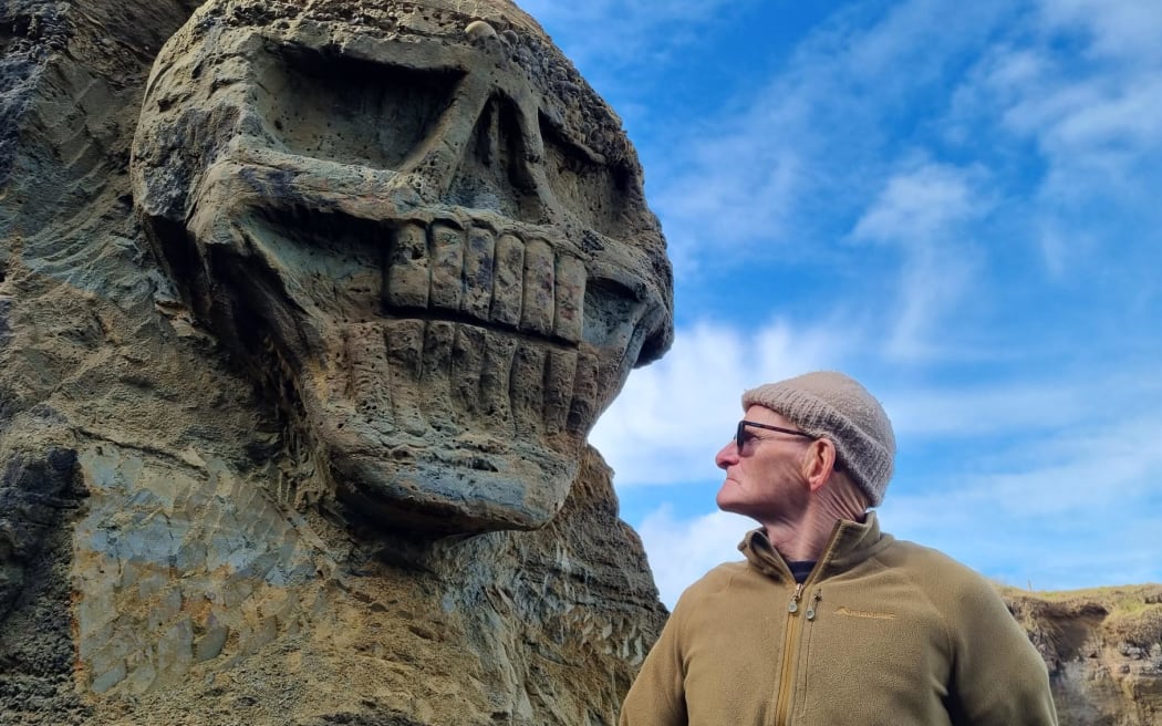 A skull carved into the sandstone cliffs at Waipipi Beach.