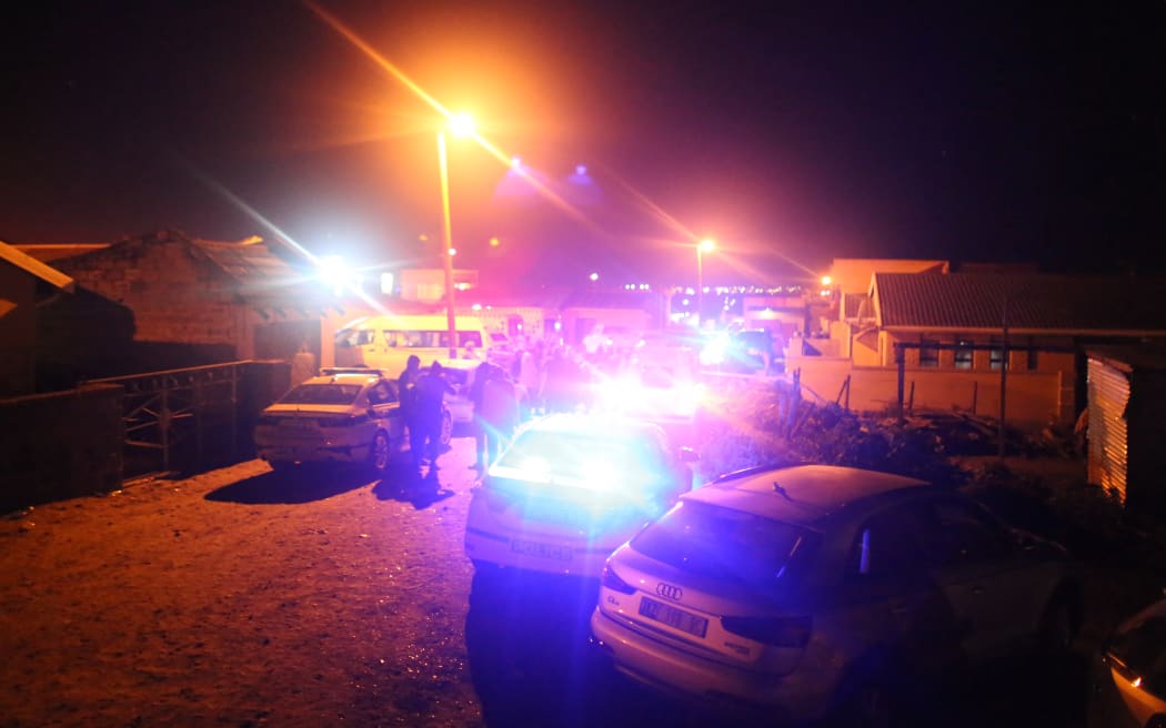 Police outside a township pub in South Africa's southern city of East London on 26 June, 2022, after at least 22 young people died inside.