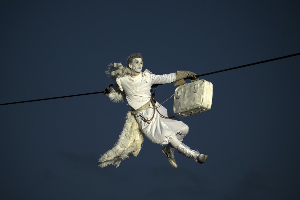 A performer is suspended from high-wires during the outdoor aerial performance of the show "Place des Anges" (Angels' square).