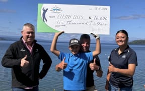 Elijah Ellis with his $10,000 cheque after winning the Hole in One Challenge at Lake Taupo.