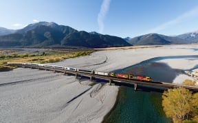 The TranzAlpine train crosses the Waimakariri bridge.