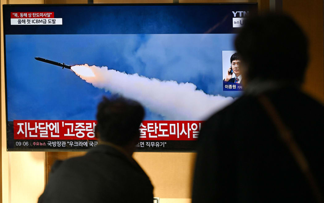 People watch a television screen showing a news broadcast with file footage of a North Korean missile test, at a train station in Seoul on October 31, 2024. - North Korea on October 31 fired a "long-range ballistic missile", South Korea's military said, Pyongyang's first weapons test since Seoul accused it of sending tens of thousands of soldiers to Russia. (Photo by JUNG YEON-JE / AFP)