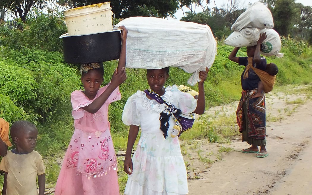 Residents of Kakate village near the town of Witu, Lamu county, carry belongings as they left their homes after last month's attack.