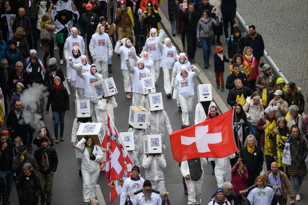 Protesters hold flags and banners during a protest in Lausanne, western Switzerland, against the country's current measures to tackle the spread of the coronavirus.