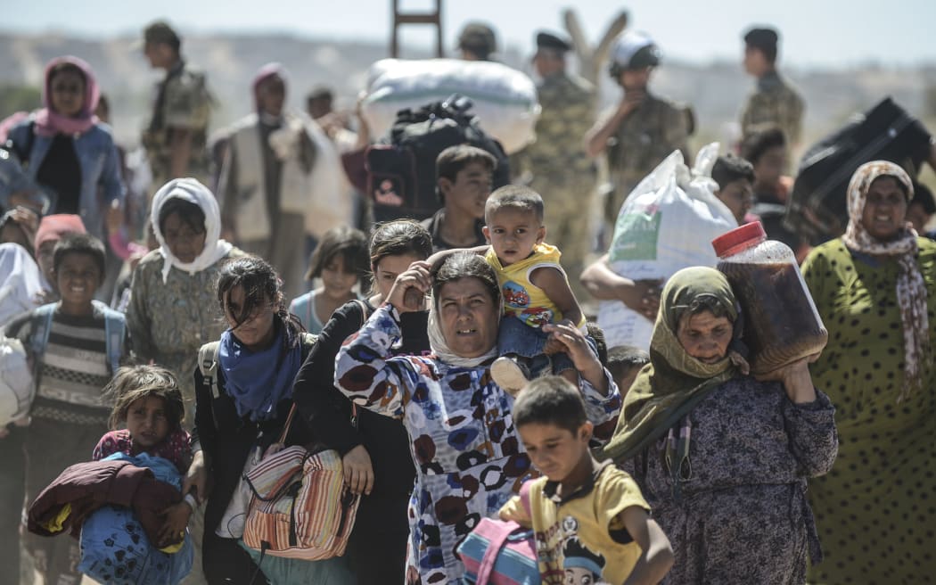 Syrian Kurds cross the border from Syria into Turkey near the southeastern town of Suruc in Sanliurfa province.