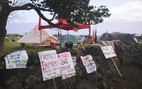 Protest signs and tents at Ihumātao.
