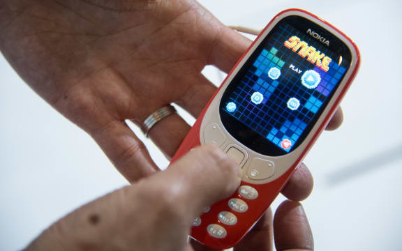 A person plays "Snake" game on the upgraded "Nokia 3310" model in 2017.