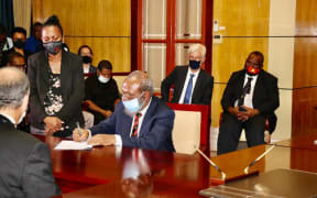 PNG's Petroleum Minister Kerenga Kua signs the Papua LNG Project Agreement with representatives of developers Total and partners ExxonMobil and Oil Search. 9 February, 2021