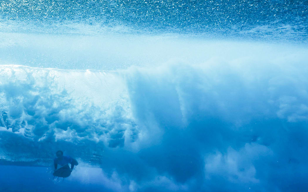New Zealand's Billy Stairmand duck dives a wave in the 5th heat of the men's surfing round 1, during the Paris 2024 Olympic Games, in Teahupo'o, on the French Polynesian Island of Tahiti, on July 27, 2024.
