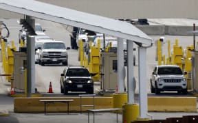 Vehicles cross at the US Customs between Windsor, Canada and Detroit, Michigan on 18 March.