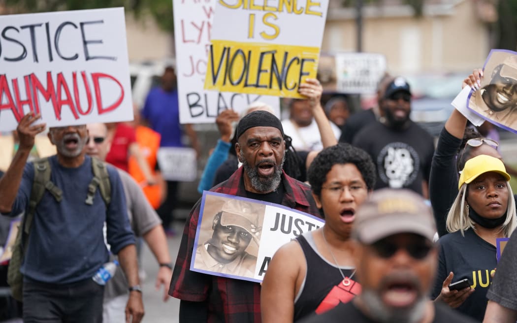 Demonstrators march near the Glynn County Courthouse where the trial for the killers of Ahmaud Arbery is taking place.