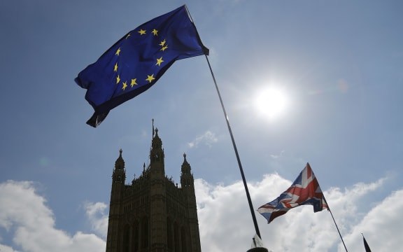 Protestor flags fly opposite the Houses of Parliament in London, Thursday, April 11, 2019.