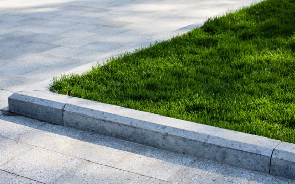 Green lawn on driveway, landscaping, berm.