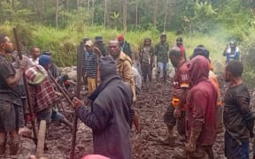 Villagers work to recover bodies after a landslide in Papua New Guinea's Enga province.