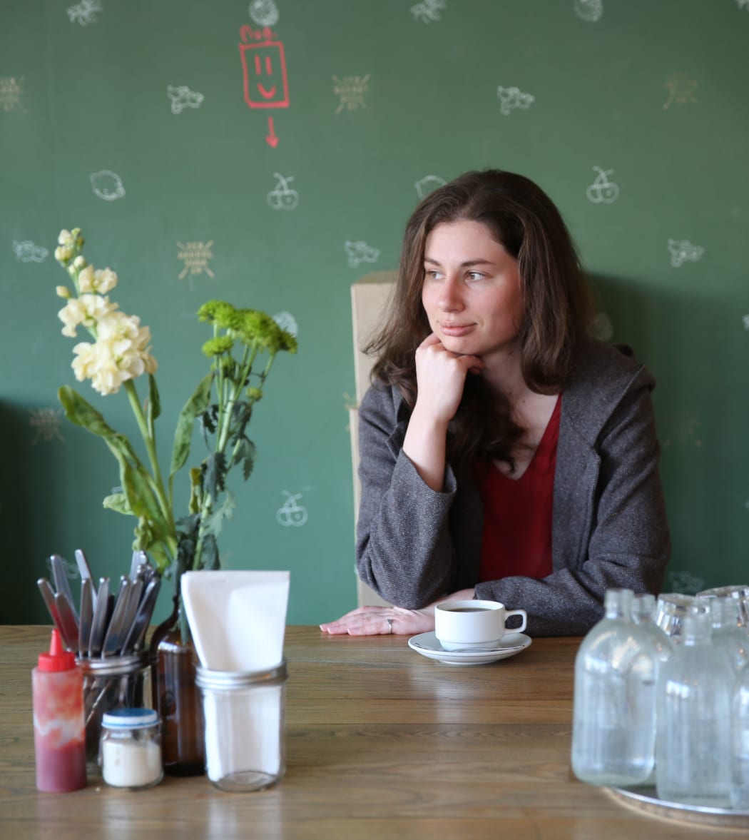 A picture of Pip Howells looking pensive alone in a cafe
