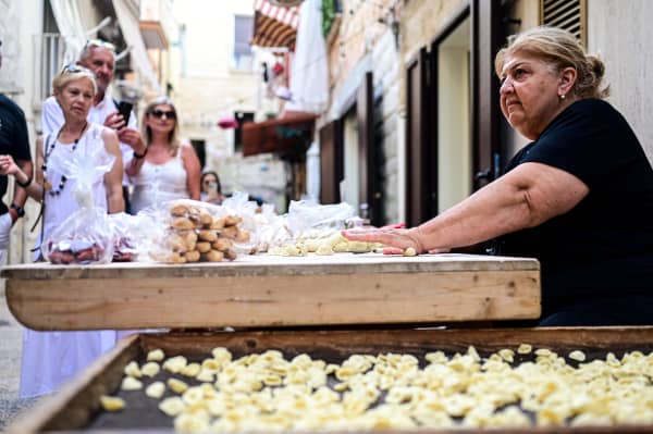 Nunzia, prepares homemade orecchiette pasta in the street at Bari Vecchia, Apulia, on June 11, 2024.