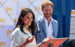(FILES) In this file photo taken on October 02, 2019 Meghan, Duchess of Sussex(L), is watched by Britain's Prince Harry, Duke of Sussex(R) as  she delivers a speech in Johannesburg, on October 2, 2019.