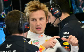 Red Bull Racing's New Zealand driver Liam Lawson speaks with a member of his pit crew on the first day of the Formula One pre-season testing in Bahrain, 2025.