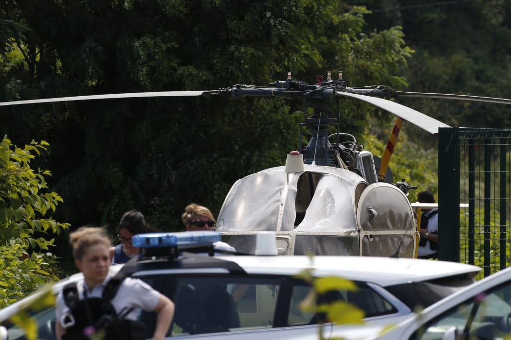 This picture taken on July 1, 2018 in Gonesse, north of Paris shows police near a French helicopter Alouette II abandoned by French armed robber Redoine Faid after his escape from prison in Reau.