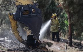 170224 CHRIS SKELTON / POOL
Firefighters continue their efforts on Saturday as they work to dampen down remaining hot spots and create a buffer zone around the 24km perimeter fire ground in Christchurch's Port Hills. Pictured Rural firefighter Aaron Kinnane (City Care firefighter)