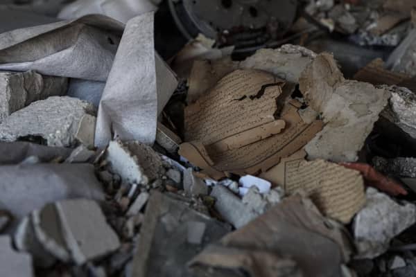 A damaged book sits in a pile of rubble at the site of the Great Omari Mosque.