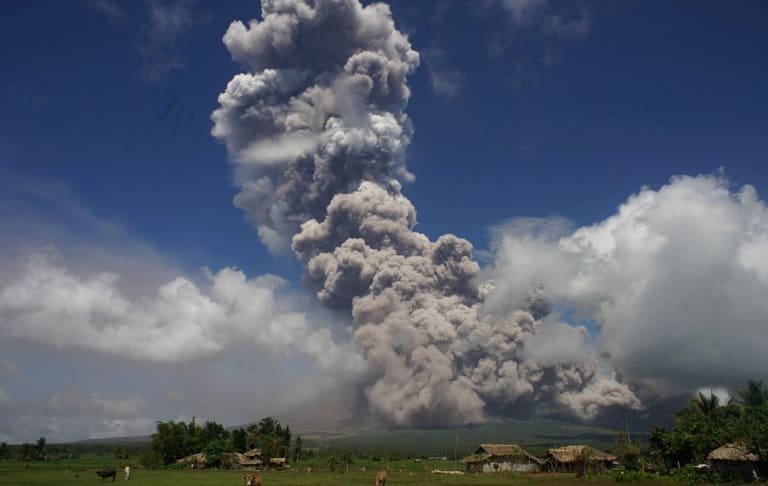 A giant cloud rises into the air from the Mayon volcano, seen from the highway in the town of Camalig, south of Manila.