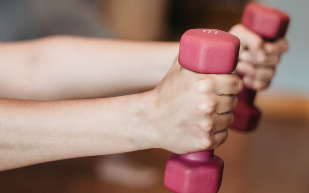 Person holding small hand weights