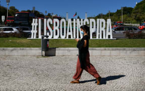 A woman wearing protective mask walks near the Eduardo VII square, Lisbon, Portugal. 07 October 2021.