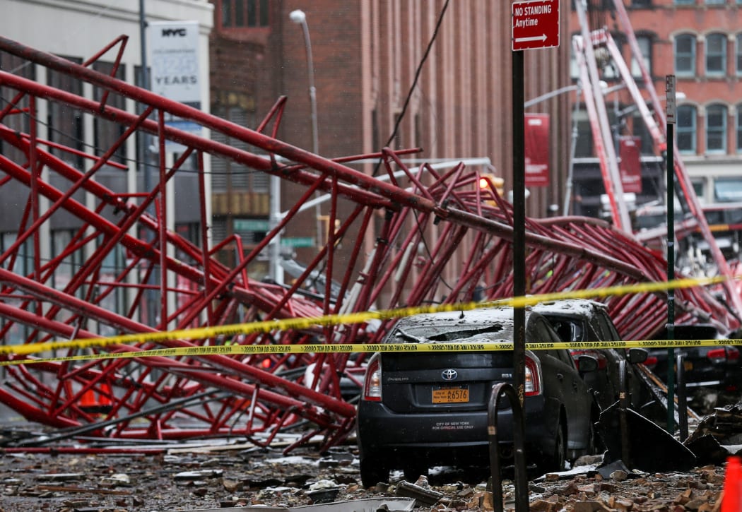 One person, who was sitting in a parked car, was killed when the crane crashed down on top of them.